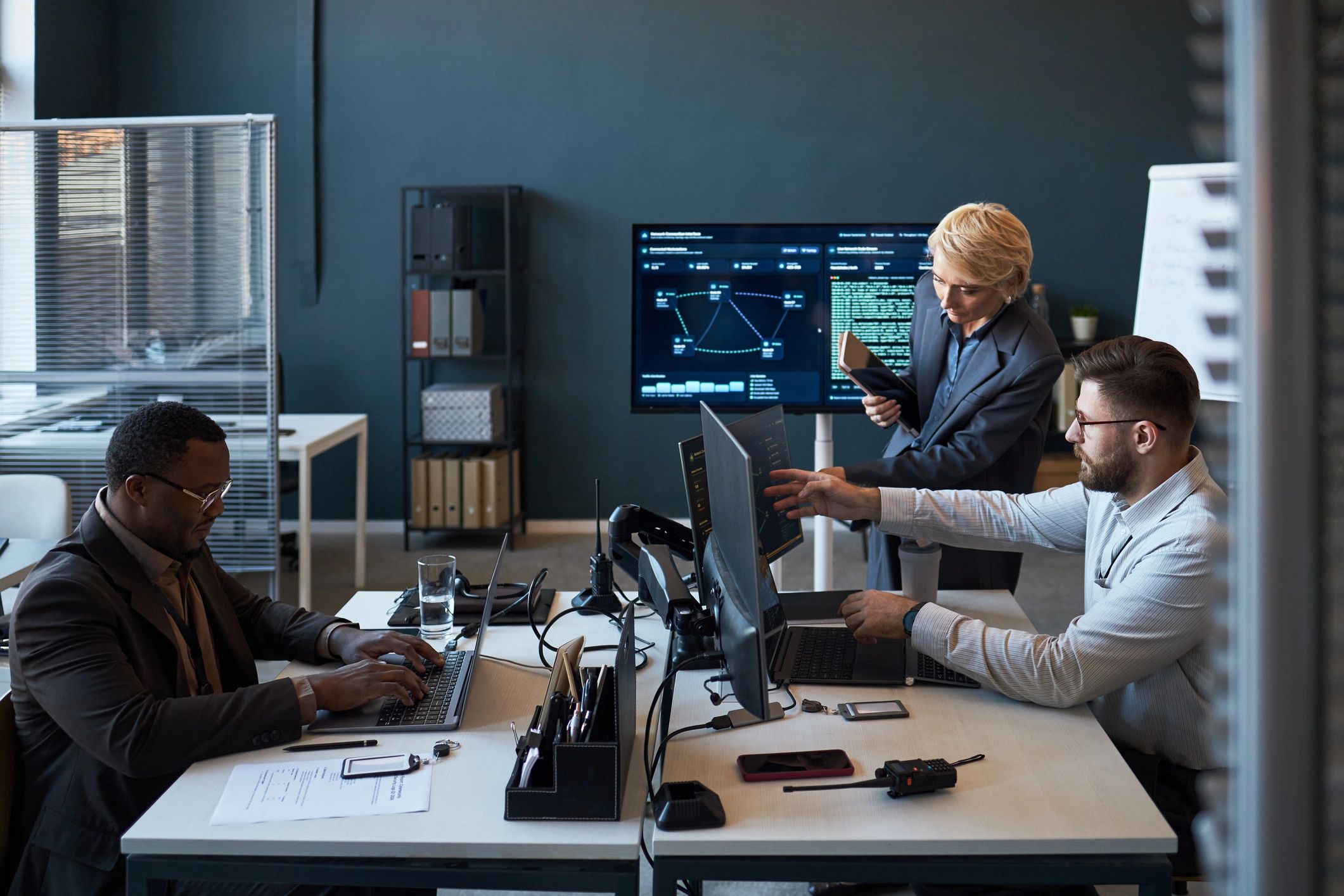 Business IT team reviewing cybersecurity dashboards in an office